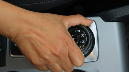 Driver's hand shifts the car gearbox modes such as parking and drive mode and parking brakes. Automatic electronic transmission and gear shift, P Park to D Drive and back in modern cars.