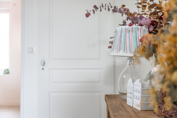 Dans un appartement rénové, vue sur la porte repeinte en blanc et le mobilier avec de la...