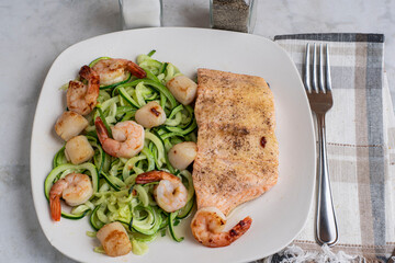 baked salmon  with zucchini noodles, shrimp and scallops