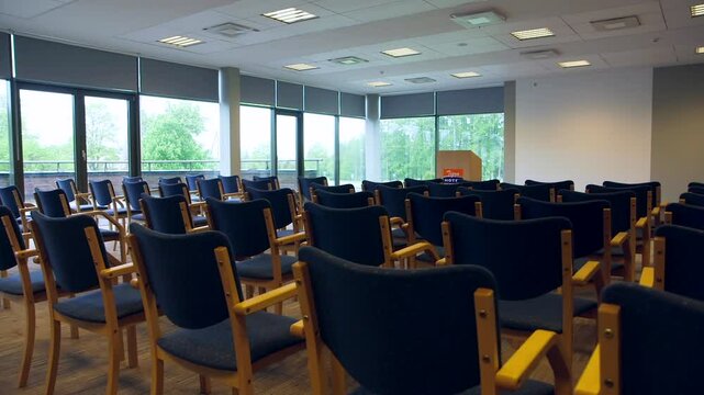 Empty, Simple Conference Room with Speakers Tribune and Classic Wooden Chairs. Conference Hall, Room, or Meeting Room is a Room Provided for Singular Events Such as Business Conferences and Meetings.