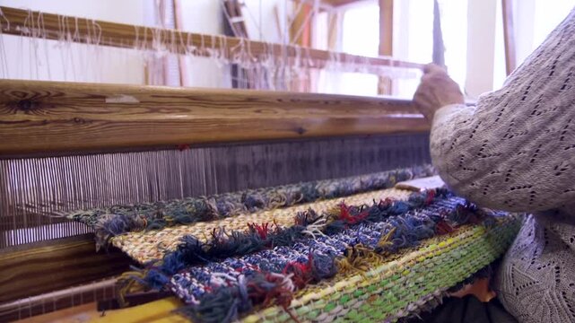 An Old Woman With Large Looms Weaves a Colorful, Decorative Tapestry or Carpet. Weaving is a Method of Textile Production in Which Two Sets of Yarns are Interlaced to Form a Fabric or Cloth.