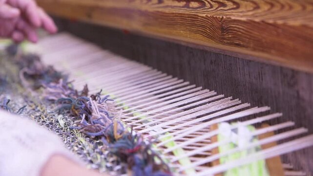 An Old Woman With Large Looms Weaves a Colorful, Decorative Tapestry or Carpet. Weaving is a Method of Textile Production in Which Two Sets of Yarns are Interlaced to Form a Fabric or Cloth.