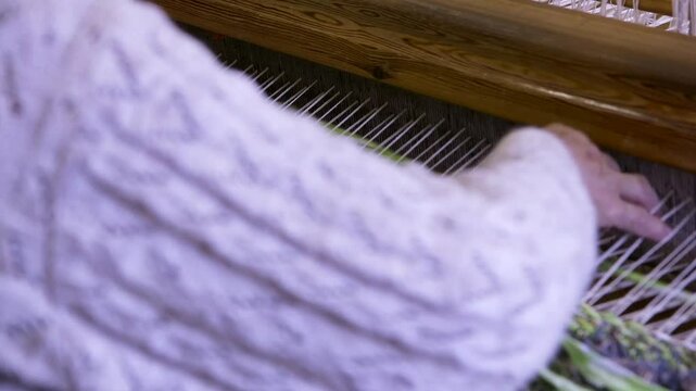 An Old Woman With Large Looms Weaves a Colorful, Decorative Tapestry or Carpet. Weaving is a Method of Textile Production in Which Two Sets of Yarns are Interlaced to Form a Fabric or Cloth.