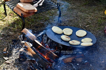 A close up on dumplings or shortbread cookies baked by using an iron pan laying in the firewood...
