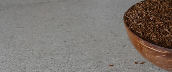 Cumin seeds in a wooden coconut bowl