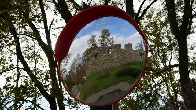 Ancient medieval castle ruins, stone masonry wall seen through convex mirror. Convex Mirror is a Curved Mirror, where the Mirror Lens Curves Outwards to Provide a Wider Angle of Viewing.