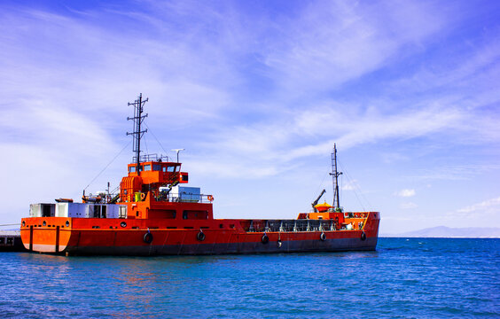 Empty cargo ship anchored on calm blue sea. Big ship and seascape view.