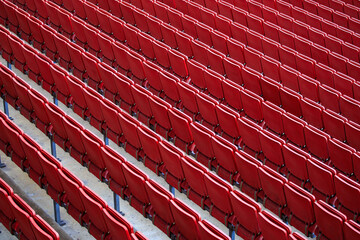 The empty seats in the stadium are red and arranged in rows