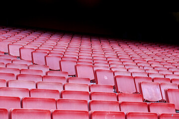 Red auditorium with empty seats and a green sign on the wall