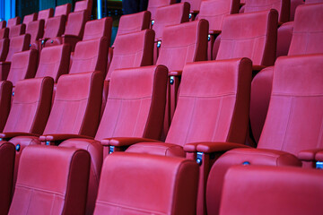 Fototapeta premium Row of red chairs are empty in a theater