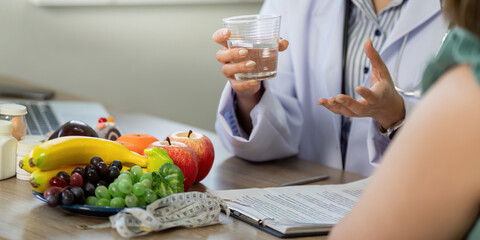 Nutrition and Wellness. A healthcare provider holds a glass of water while discussing hydration.