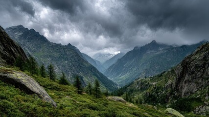 Fototapeta premium Dramatic mountain landscape with a valley under a cloudy, overcast sky.
