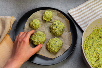 Homemade vegan spinach and chickpea flour patties. Hand creating patties and placing on plate