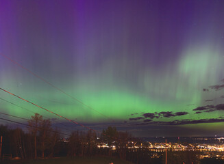 Aurora borealis in the sky above a city center