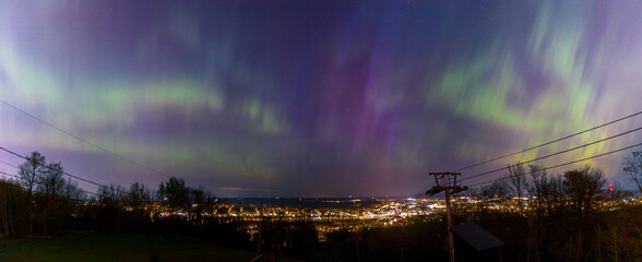 Aurora borealis in the sky above a city center