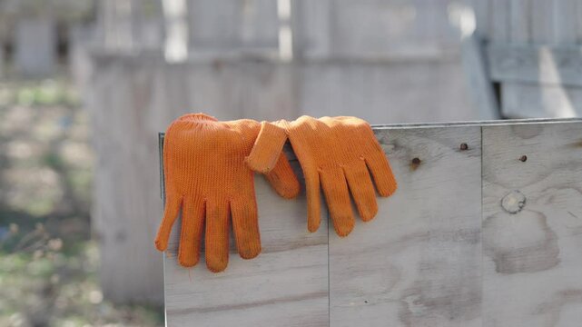 Orange Work Gloves Resting on Wooden Beam, Construction Site Break, Builder Safety Equipment in Outdoor Workshop
