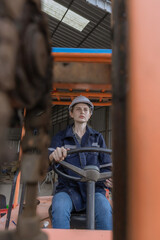 WoMan worker at forklift driver happy working in industry factory logistic ship. Woan forklift driver in warehouse area..Forklift driver sitting in vehicle in warehouse