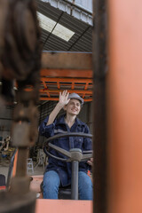 WoMan worker at forklift driver happy working in industry factory logistic ship. Woan forklift driver in warehouse area..Forklift driver sitting in vehicle in warehouse