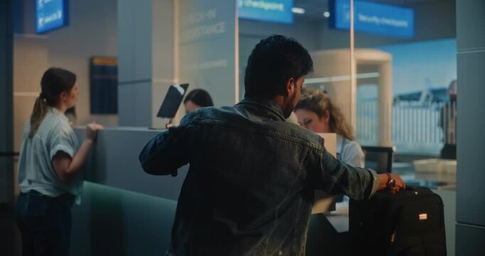 Indian Man Giving Passport and Ticket at Check-in Counter, Placing Suitcase for Baggage Check, Putting Finger on Digital Tablet for ID Biometric Scanning. Security Checkpoint in Airport Terminal.