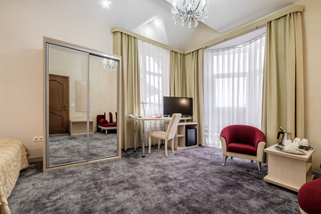Modern hotel room with desk and armchairs