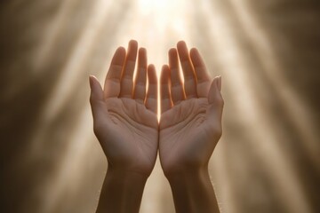 Two hands cupped upwards catching bright light rays in a soft focus neutral colored background scene