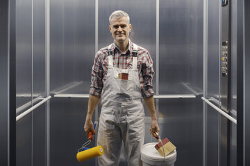 Happy professional painter posing in the elevator © stokkete