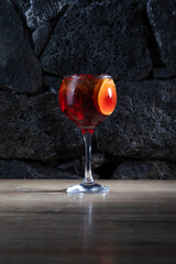 Fresh Spritz cocktail with orange slice and ice, on dark rocks background, stock