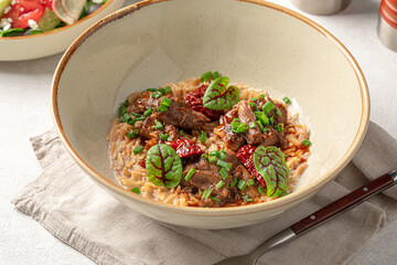 Portion of gourmet pasta orzo with meat and basil