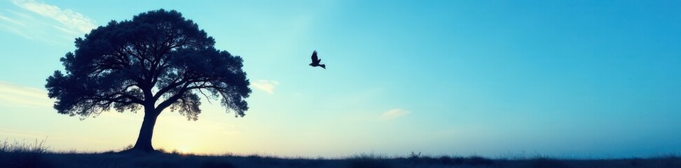 Silhouette of tree against blue sky with bird in flight, wildlife, tree silhouette