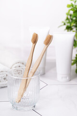 White Cosmetic Tubes and Bamboo Toothbrushes in Bright Minimalist Bathroom Scene