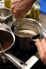 chef cocinando y elaborando bechamel en una cazuela de acero inoxidable
