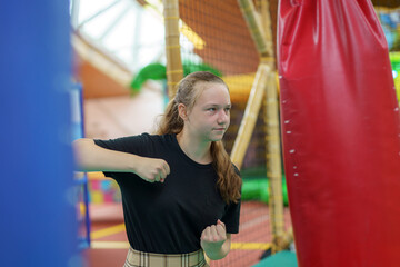 Obraz premium A girl punches a punching bag at a play park.