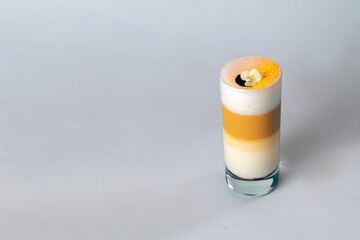 Yellow creamy layered drink on white background