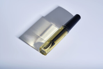 Bottle with brush filled with oil for eyebrow and eyelash growth. 