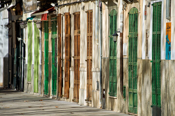 Bunte Fensterläden und Fassaden einer charmanten Straße in Arta auf Mallorca, Spanien.