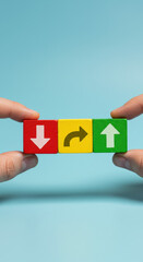 Arrow Blocks: Directional Strategy, Business Growth, Choice & Opportunity - Red, Yellow, Green Cubes Held by Hands on Blue Background