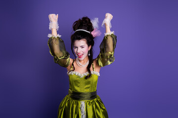 Elegant woman in a green baroque dress exuding royalty against a vibrant purple background