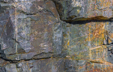 Weathered metamorphic rock texture, colorful stone surface, natural pattern, outdoor, daylight