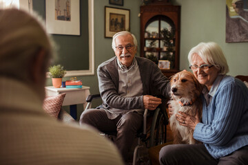 Happy group of senior friends enjoying coffee and cake together at home