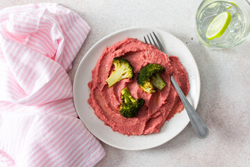 A balanced breakfast with beetroot hummus and broccoli, offering a wholesome start to the day