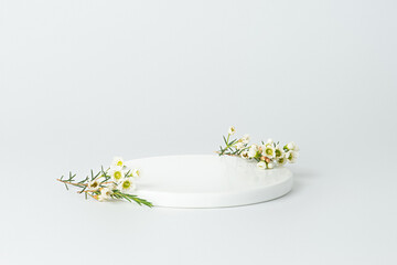 White background with flowers and white podium © Berzyk