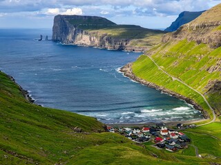 Panoramic shot of the small, picturesque village of Tjornuvik on Faroe Islands surrounded by the mountains