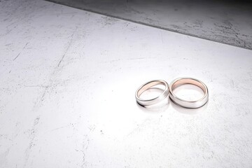 Two Wedding Rings on Textured Surface - Two wedding rings symbolize commitment, love, marriage, and forever. A textured surface adds depth and elegance