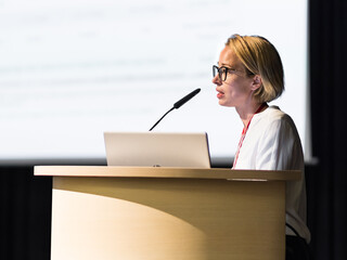 Female speaker giving a talk on corporate business conference. Business and Entrepreneurship event