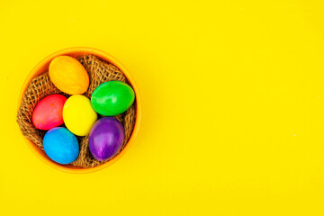 Easter Eggs in Thread-Filled Bowl Over Yellow Surface