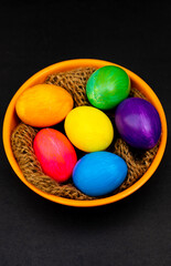 Colorful Eggs in Orange Bowl Over Black Background