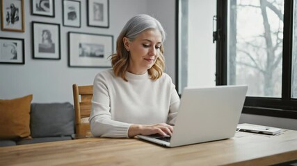A person typing away on a laptop at a table, possibly doing work or staying connected.