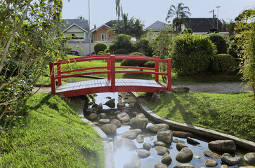 A red Japanese style bridge decorating the Japanese garden