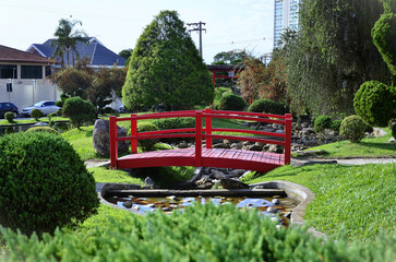 A red Japanese style bridge decorating the Japanese garden