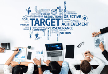 Aerial view of a business meeting with diverse professionals discussing strategies for achieving...